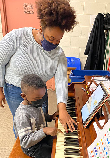 a boy takes piano lessons