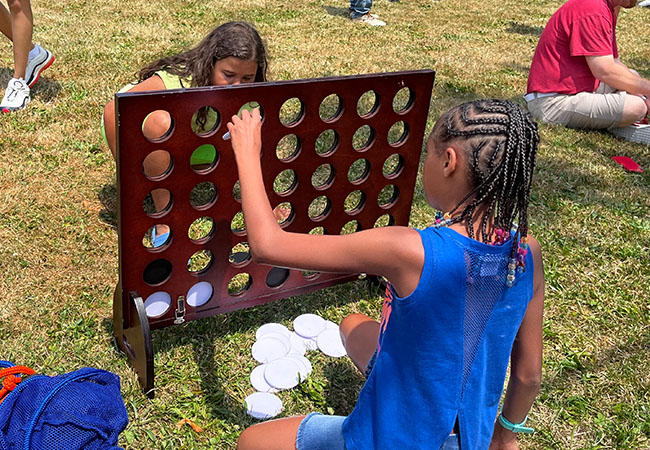 two girls playing giant connect four