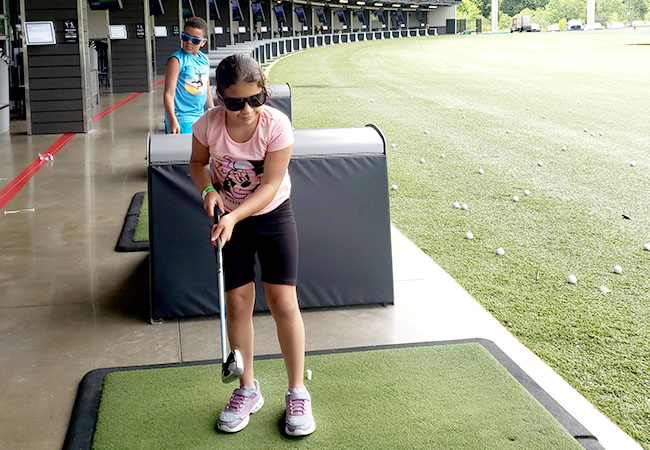 young girl at the driving range