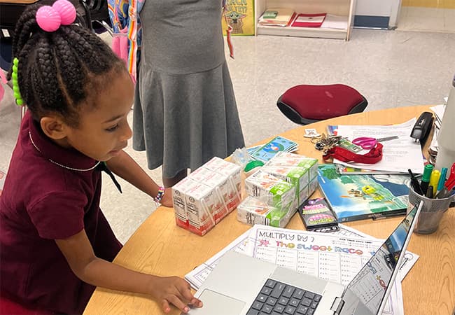 A young student works on a laptop.