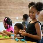 A female student works with blue play dough.