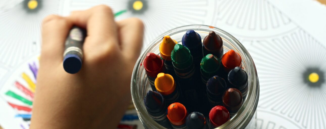 A child's hand coloring with a crayon.