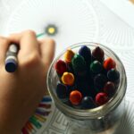 A child's hand coloring with a crayon.